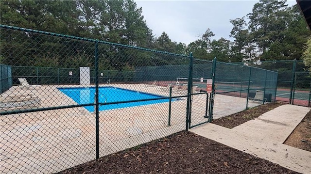 view of swimming pool featuring tennis court