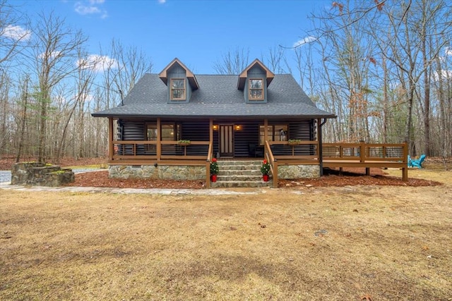 log-style house featuring covered porch and a front yard