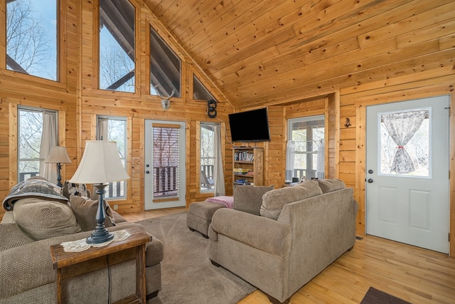 living room with high vaulted ceiling, wood walls, wood ceiling, and wood finished floors