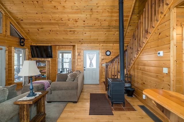 living room featuring plenty of natural light, light wood-style flooring, and a wood stove