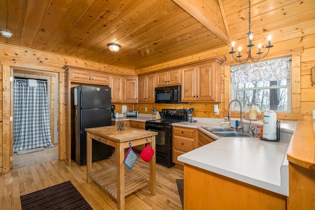 kitchen with light wood finished floors, wood ceiling, light countertops, black appliances, and a sink