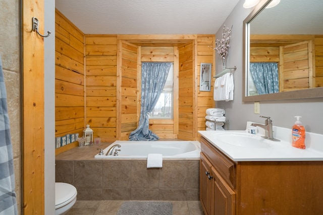 full bathroom with wooden walls, tile patterned floors, toilet, a bath, and vanity