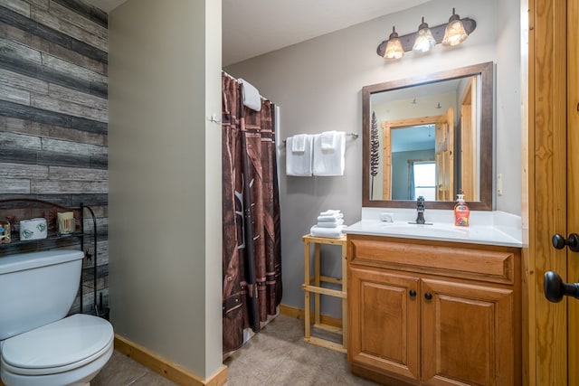 bathroom featuring baseboards, toilet, vanity, and tile patterned flooring