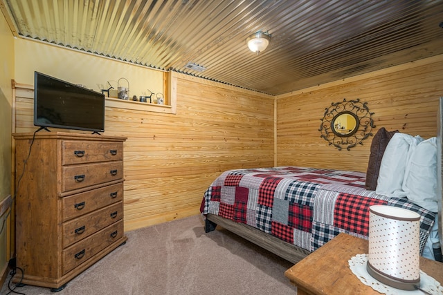 bedroom featuring wooden walls, wooden ceiling, and carpet