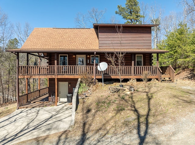 view of front facade featuring a porch, driveway, and roof with shingles