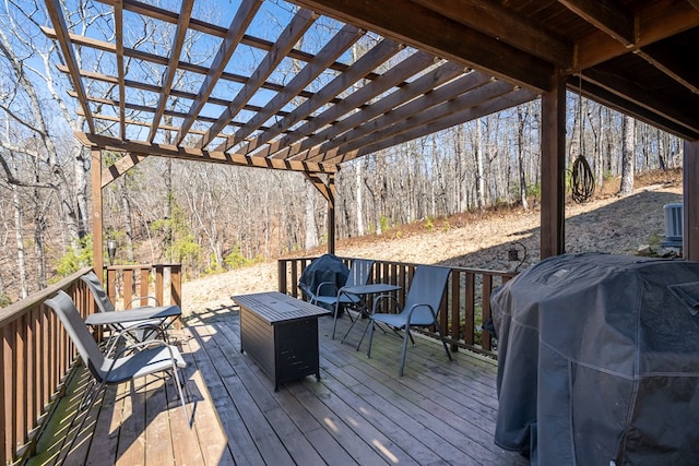 wooden deck with a grill and a forest view