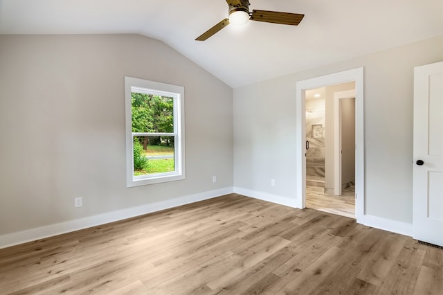 unfurnished bedroom featuring light hardwood / wood-style floors, lofted ceiling, ensuite bathroom, and ceiling fan