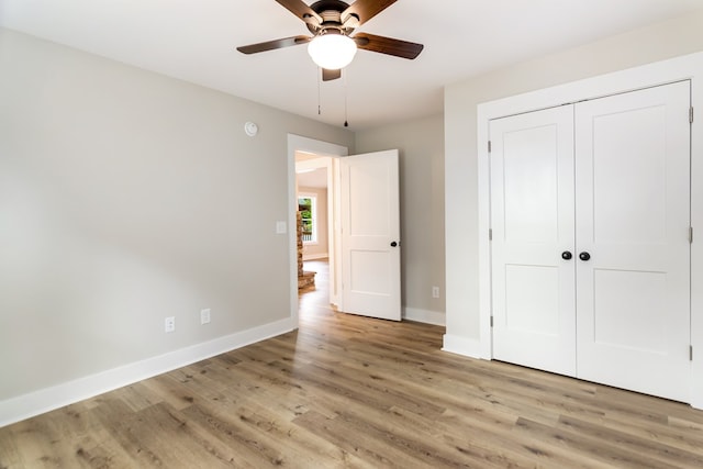 unfurnished bedroom featuring light hardwood / wood-style floors, a closet, and ceiling fan