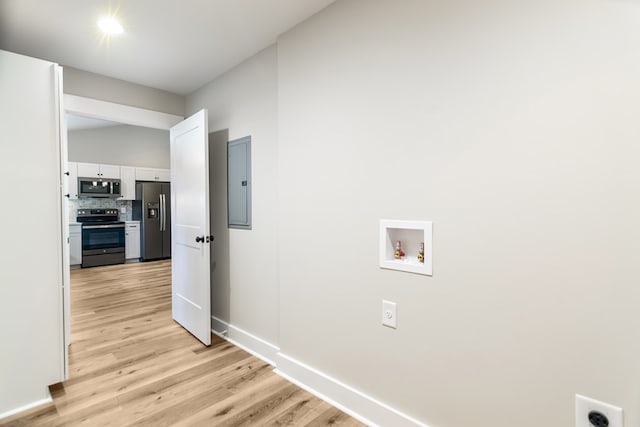 washroom featuring electric panel, washer hookup, and light wood-type flooring