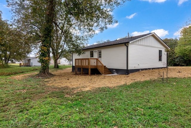 rear view of property with a yard and a wooden deck