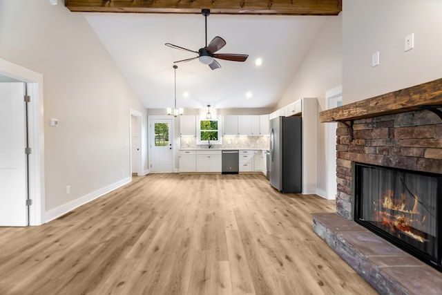 unfurnished living room with beam ceiling, high vaulted ceiling, light hardwood / wood-style flooring, and a fireplace