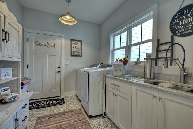 laundry area featuring sink, light tile patterned floors, cabinets, and independent washer and dryer