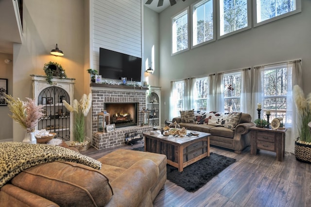 living room featuring hardwood / wood-style flooring, a brick fireplace, and a wealth of natural light