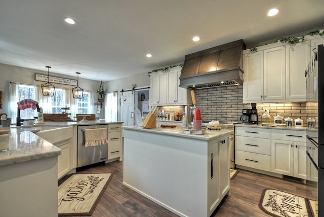 kitchen with custom exhaust hood, a center island, stainless steel dishwasher, pendant lighting, and a barn door