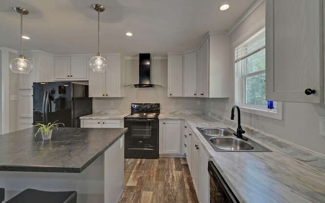 kitchen featuring dark wood-style flooring, a sink, white cabinets, black appliances, and wall chimney exhaust hood