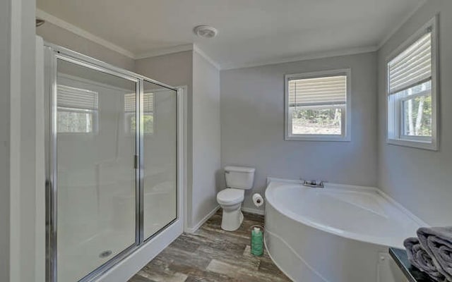 bathroom with toilet, wood finished floors, ornamental molding, a bath, and a stall shower