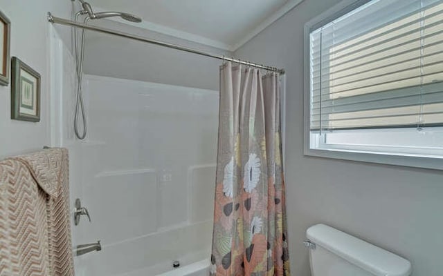 full bath featuring crown molding, shower / tub combo with curtain, and toilet