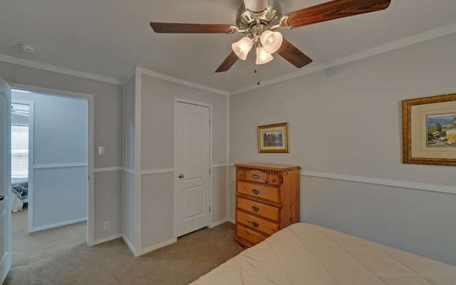 carpeted bedroom with baseboards, ornamental molding, and a ceiling fan