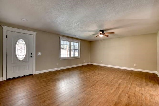 entryway with a textured ceiling, dark hardwood / wood-style floors, and ceiling fan