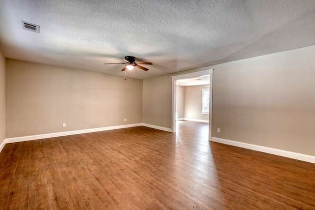 unfurnished room featuring ceiling fan, dark hardwood / wood-style flooring, and a textured ceiling