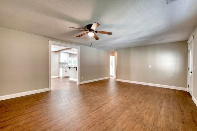 empty room featuring a textured ceiling, dark hardwood / wood-style flooring, and ceiling fan