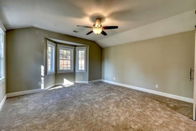 carpeted spare room with ceiling fan and lofted ceiling