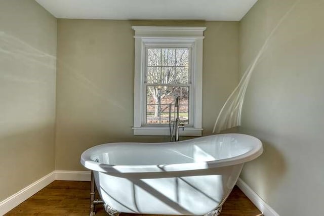 bathroom featuring a washtub and hardwood / wood-style flooring