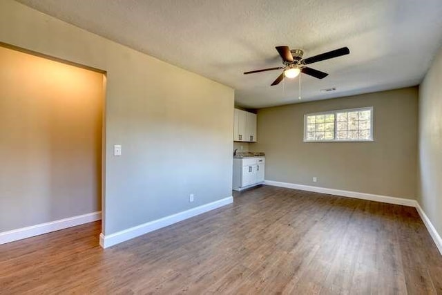 spare room with ceiling fan, hardwood / wood-style floors, and a textured ceiling