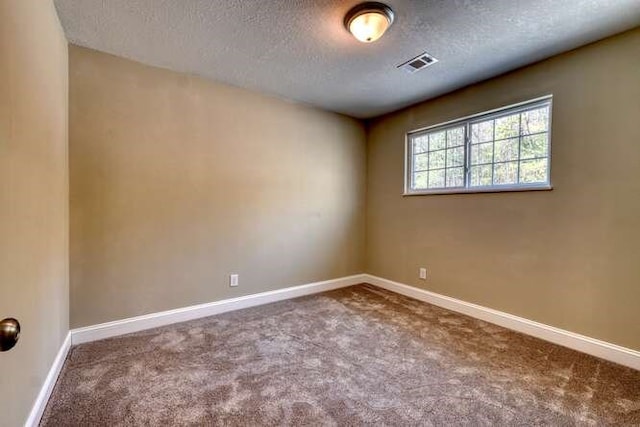 spare room featuring carpet and a textured ceiling