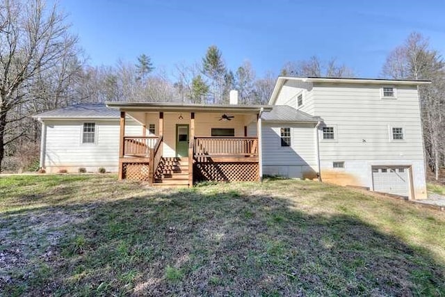 back of house with ceiling fan, a garage, a yard, and a wooden deck