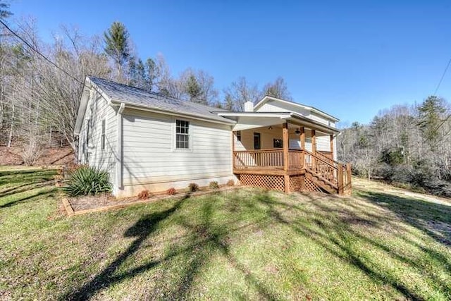 back of property featuring covered porch and a yard