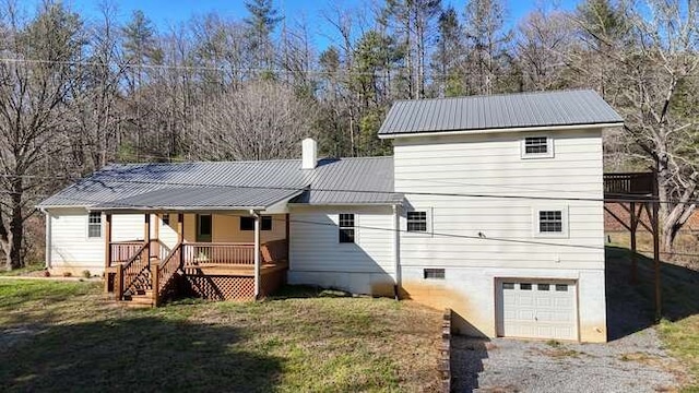 rear view of property with a lawn and a garage