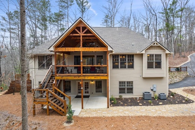 rear view of property featuring stairs, a shingled roof, a patio area, and central air condition unit