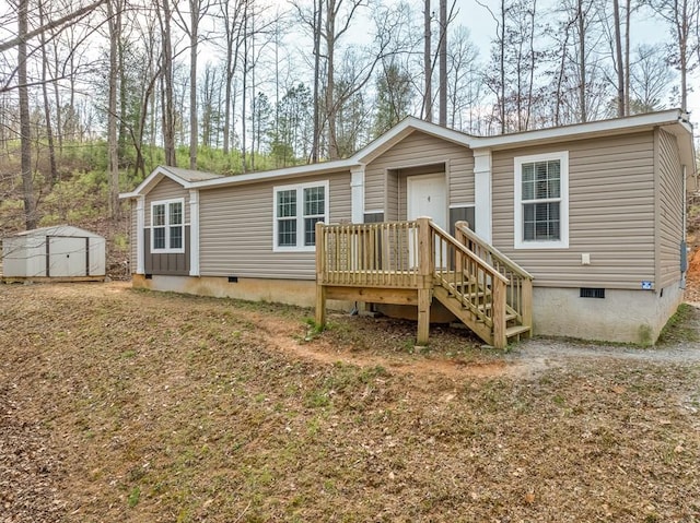 view of front of home with crawl space, a storage shed, and an outdoor structure