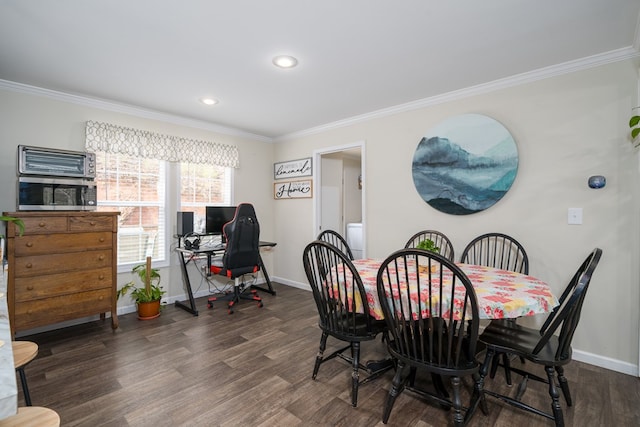 dining room with crown molding, baseboards, and wood finished floors