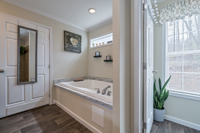 full bath with a garden tub, crown molding, visible vents, wood finished floors, and baseboards