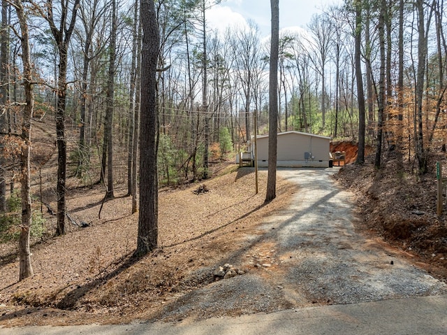 exterior space with driveway and a view of trees