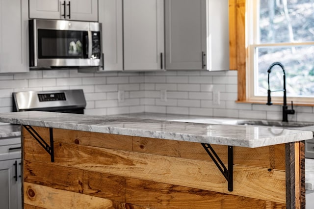 kitchen with sink, backsplash, and light stone counters