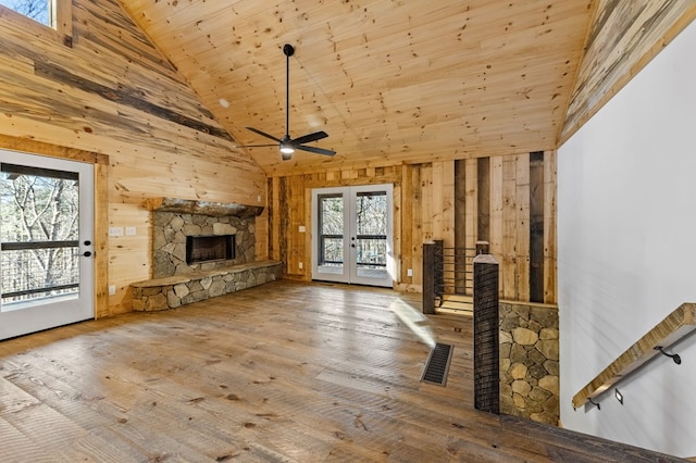 unfurnished living room with hardwood / wood-style floors, a fireplace, wood ceiling, french doors, and high vaulted ceiling