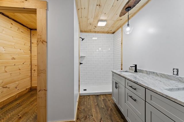 bathroom featuring vanity, hardwood / wood-style flooring, tiled shower, and wooden ceiling