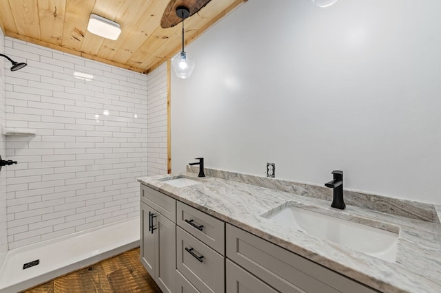 bathroom with tiled shower, vanity, and wood ceiling