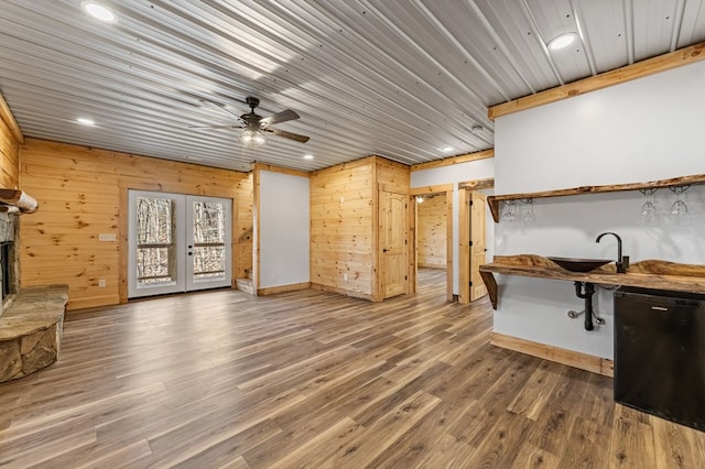 living room with a fireplace, wood ceiling, hardwood / wood-style flooring, wooden walls, and ceiling fan