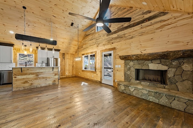 unfurnished living room featuring high vaulted ceiling, wooden ceiling, hardwood / wood-style flooring, and a stone fireplace