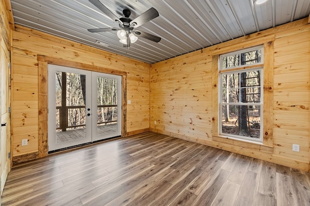 empty room featuring wood walls and french doors