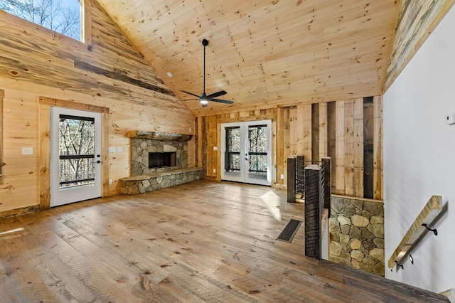 unfurnished living room with a fireplace, wooden ceiling, plenty of natural light, and high vaulted ceiling