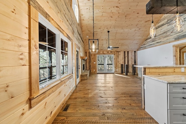 interior space with wooden ceiling, dark hardwood / wood-style flooring, wood walls, and a healthy amount of sunlight