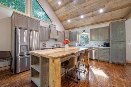 241 Lees Ride, Mccaysville, GA 30555 - kitchen with appliances with stainless steel finishes, a kitchen island, high vaulted ceiling, custom range hood, and a kitchen bar