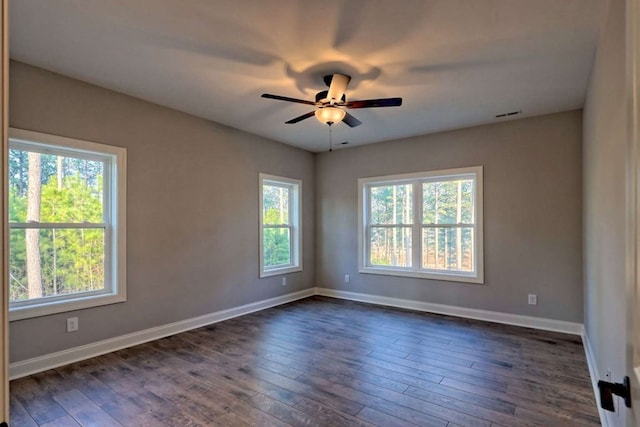 unfurnished room with ceiling fan, baseboards, dark wood-style floors, and visible vents