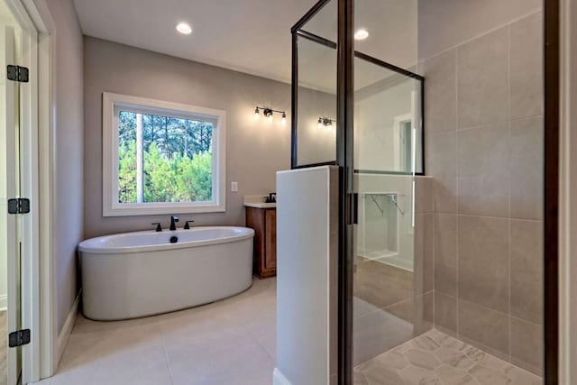 bathroom featuring a stall shower, a soaking tub, tile patterned flooring, vanity, and recessed lighting