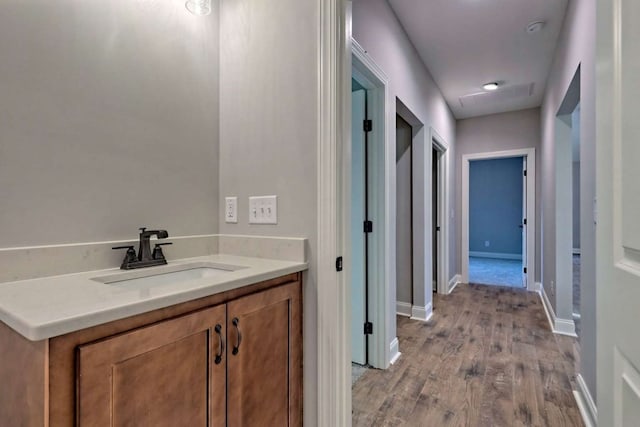 bathroom with vanity, wood finished floors, and baseboards